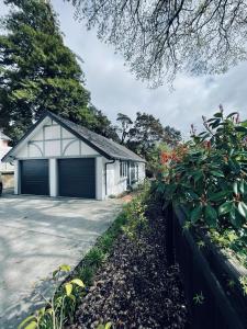 a house with a garage next to a driveway at Chatsworth Cottage in Upper Hutt