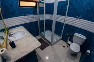 Baño azul con lavabo y aseo en Guest House Montanha, en Mindelo