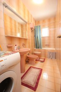 a bathroom with a toilet and a sink and a washing machine at Apartments and rooms with parking space Srebreno, Dubrovnik - 8959 in Mlini