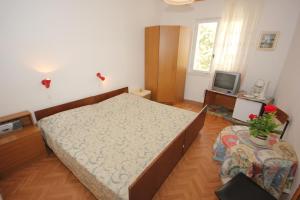 a bedroom with a large bed and a television at Apartments and rooms with parking space Srebreno, Dubrovnik - 8959 in Mlini