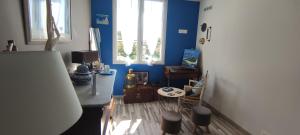 Cette chambre aux murs bleus dispose d'une table et d'un réfrigérateur. dans l'établissement 2 chambres côté plage, à Hyères