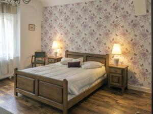 1 dormitorio con 1 cama grande con flores en la pared en Gîte Thillombois, 6 pièces, 12 personnes - FR-1-585-38, 