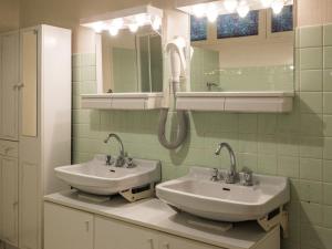 ein Badezimmer mit zwei Waschbecken und einem Telefon an der Wand in der Unterkunft Gîte pour 12 face au château de Thillombois avec jardin, cheminée et équipements PMR - FR-1-585-38 in Thillombois + 27 Fotos