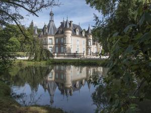un antiguo castillo reflejado en el agua de un lago en Gîte Thillombois, 6 pièces, 12 personnes - FR-1-585-38, 