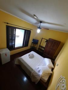a bedroom with a large white bed in a room at Pousada Por do Sol in Serra Negra