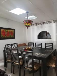 een eetkamer met een zwarte tafel en stoelen bij Casa entera, los clientes pueden usar todo el espacio y no tendrán que compartirlo con el anfitrión ni con otros huéspedes in Barrancabermeja