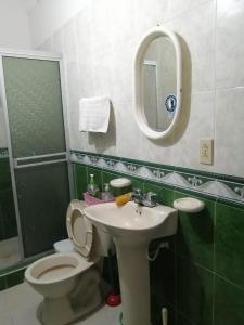 een badkamer met een toilet, een wastafel en een spiegel bij Casa entera, los clientes pueden usar todo el espacio y no tendrán que compartirlo con el anfitrión ni con otros huéspedes in Barrancabermeja
