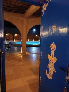 a door with a lizard painted on it next to a pool at Hotel Riad Ali in Merzouga