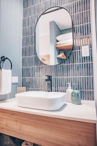 a bathroom with a white sink and a mirror at Banjo Paterson Inn in Jindabyne