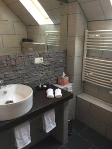 a bathroom with a sink and a toilet and a tub at Hotel Achilles in Kirkel