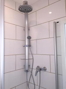 a shower with a shower head in a bathroom at Hotel Achilles in Kirkel