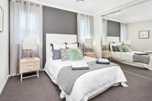 1 Schlafzimmer mit 2 Betten und einem großen Spiegel in der Unterkunft Luxury Brand New Home in Shellharbour