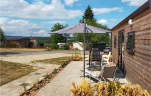 un parasol et des chaises sur un trottoir à côté d'un bâtiment dans l'établissement Stunning Home In Haller With Wifi, à Haller