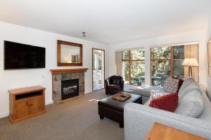 uma sala de estar com um sofá e uma lareira em Northstar at Stoney Creek by Whiski Jack em Whistler