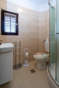 a bathroom with a toilet and a glass shower at Apartments by the sea Mandre, Pag - 3084 in Kolan