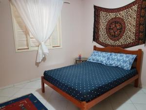 een slaapkamer met een bed met een kussen en een raam bij Linda casa c/Piscina, Ar e conforto próximo do Mar in Itapoa