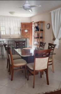 a kitchen with a dining room table and chairs at Linda casa c/Piscina, Ar e conforto próximo do Mar in Itapoa