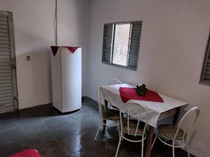 a dining room with a table and a white refrigerator at Casa Cogumelo Azul in São Thomé das Letras +2 photos