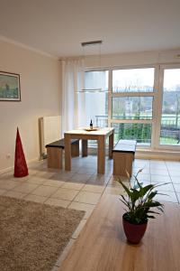 a living room with a table and a large window at Schmuckstück in Essen in Essen