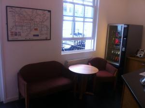 a room with two chairs and a table and a map on the wall at Colliers Hotel in London