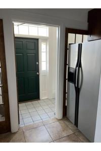 a kitchen with a green door and a refrigerator at Grand Old White Capitol Executive Suite in Charleston