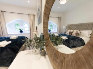 a bedroom with two beds and a large mirror at Pilgrims Loft in Ventnor