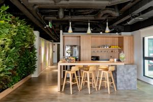 a kitchen with a large wooden island with stools at Hello World Saigon in Ho Chi Minh City