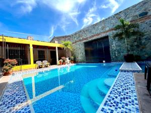 una piscina en una casa con un edificio en Hotel Boutique Mirador Las Palmas, en Honda