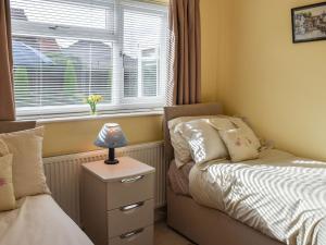 a small bedroom with a bed and a window at Tabusintac in Heacham
