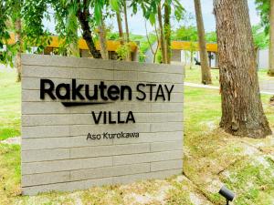 uma placa que diz cascavel ficar villa ao lado de uma árvore em Rakuten STAY VILLA Aso Kurokawa -101 1LDK Capacity of 6 persons em Minamioguni