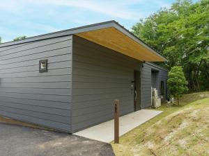 a small gray garage with a wooden roof at Rakuten STAY VILLA Aso Kurokawa -101 1LDK Capacity of 6 persons in Minamioguni