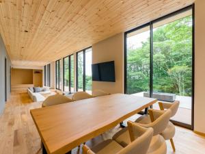 a conference room with a wooden table and chairs at Rakuten STAY VILLA Aso Kurokawa -104 1LDK pet allowed Capacity of 6 persons in Minamioguni