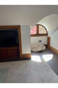 een kamer met een bed en een flatscreen-tv bij Grand Old White Artist's Loft in Charleston