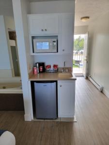 a kitchen with a sink and a microwave at Pointes North Beachfront Resort Hotel in Traverse City