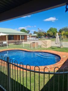 a view of a swimming pool through a fence at Regency Court Motel in Cobram