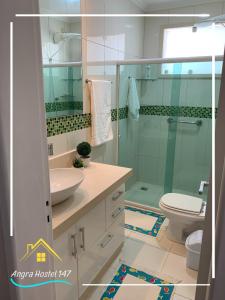 a bathroom with a shower and a sink and a toilet at Angra Hostel 147 in Angra dos Reis