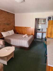 a hotel room with a bed and a table at Regency Court Motel in Cobram