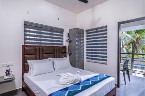 a bedroom with a bed and a balcony at Dune Homestay in Alleppey