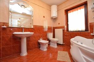 łazienka z umywalką, toaletą i lustrem w obiekcie Apartment Reno w mieście Umag +36 zdjęć