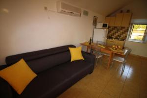 a living room with a black couch and yellow pillows at Apartment and Room Lada in Sumartin