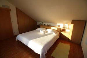 a bedroom with a large white bed with two pillows at Apartment and Room Lada in Sumartin