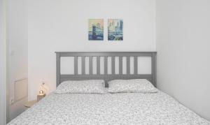 a white bedroom with a bed with two pillows at House Luxury Konforta in Brodarica