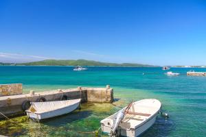 two boats are tied to a dock in the water at House Luxury Konforta in Brodarica
