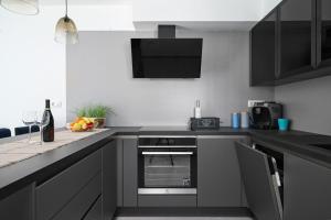 a kitchen with black cabinets and a counter top at House Luxury Konforta in Brodarica +25 photos