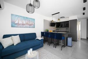 Una sala de estar con un sofá azul y una cocina. en House Luxury Konforta, en Brodarica