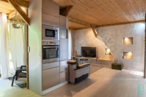 una grande cucina con piano cottura e TV di Magnifique et spacieux T2 proche de la plage - La Kiss House a Deshaies