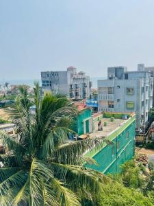 a view of a city with a palm tree and buildings at Royal Beach International in Puri