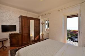 a bedroom with a bed and a tv and a window at Apartment Nando in Lovran