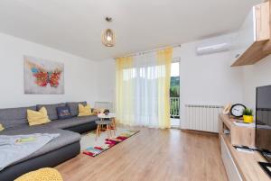 a living room with a couch and a tv at Apartment Ivona in Tribalj