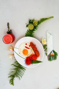 a plate of food with eggs and carrots on a table at BALI AMED FEEL HOME VILLA in Amed